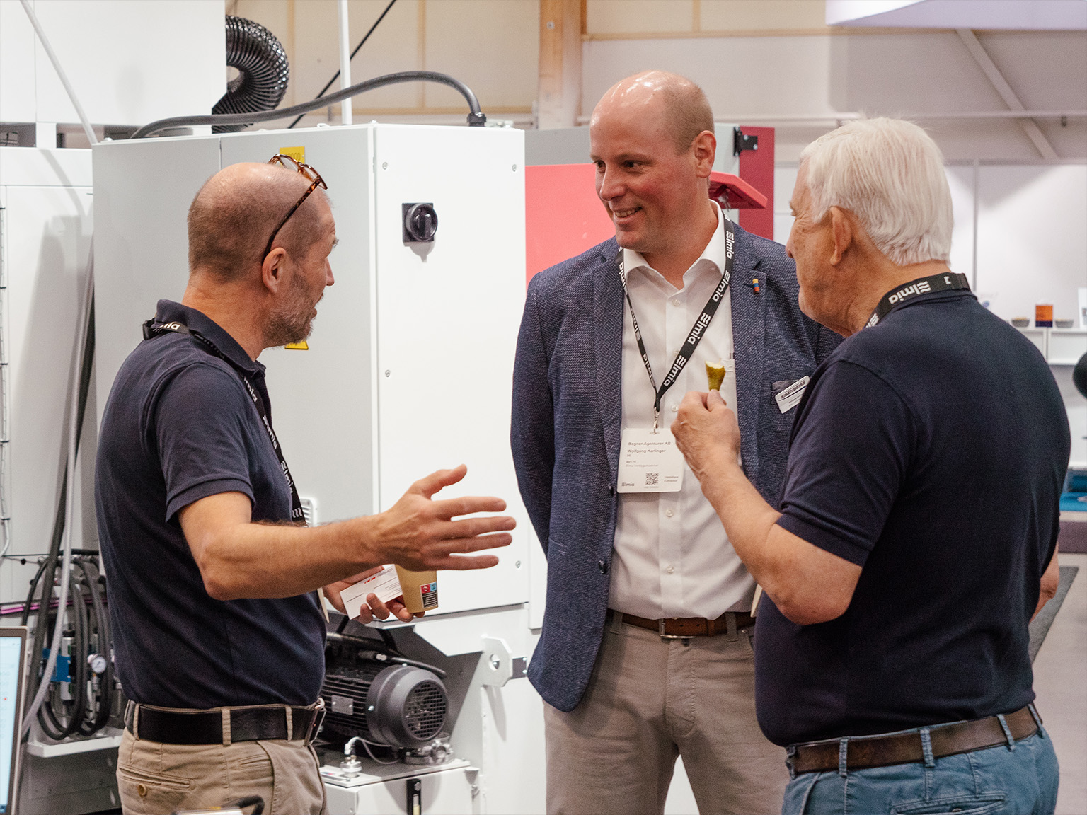 "Patrik Fredriksson, Björn Begner och Wolfgang Karlinger disskuterar i montern på Elmia Verktygsmaskiner 2024